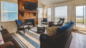 A living room with a fireplace, television, and seating area. - Beach Front Home Seconds Away From The Beach (Freeport)
