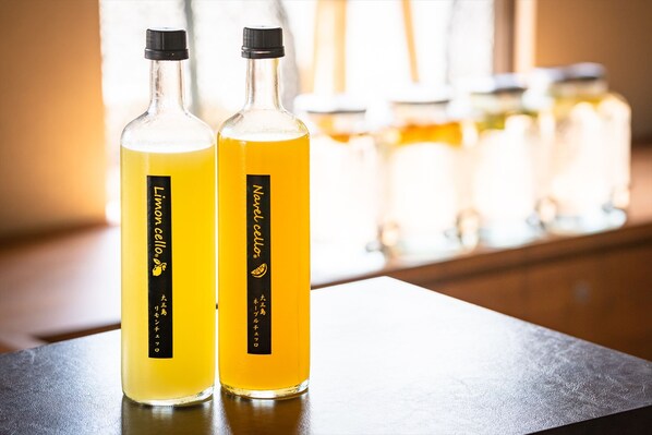 Two bottles of lemon cordial on a table with jars in the background. - I-Link Hostel & Cafe Shimanami (Imabari)