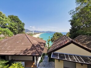 Une vue sur la côte, avec une plage, un toit recouvert de tuiles et un panneau solaire.