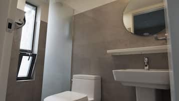 A modern bathroom with a toilet, a sink, and a shower.