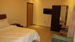 Une chambre d’hôtel équipée d’un lit, d’un téléviseur fixé au mur, d’une armoire et d’un radiateur.