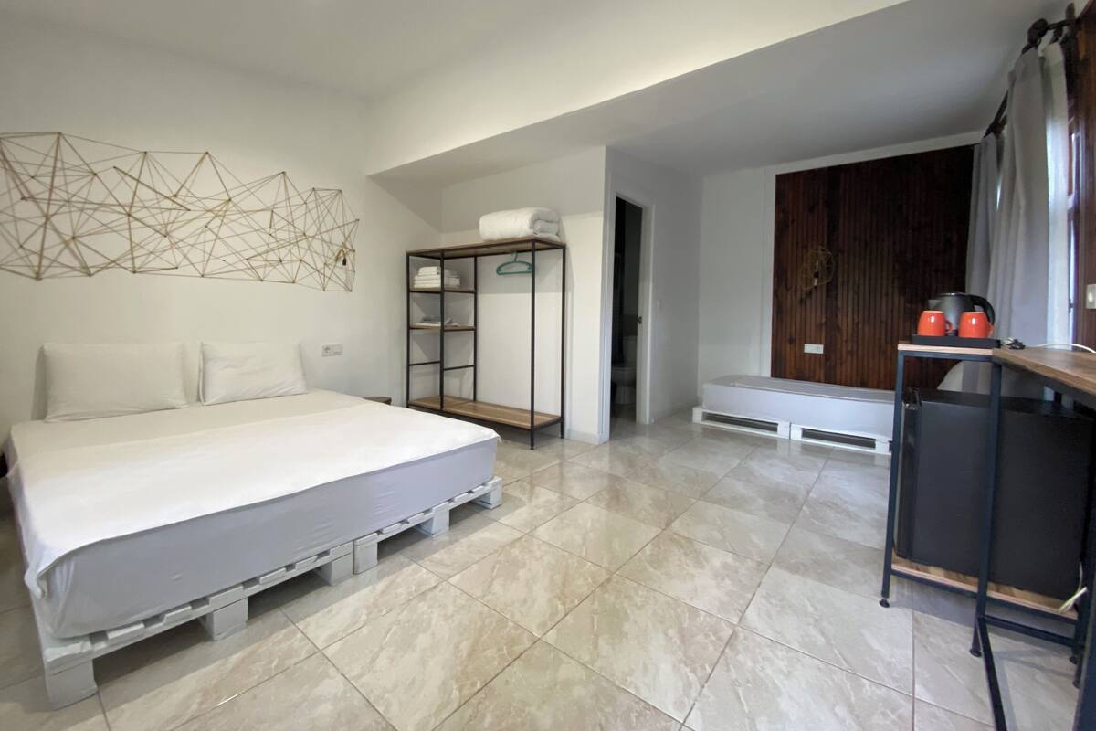 Un dormitorio moderno con cama, armario y escritorio.