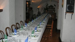 A long dining table set with plates, glasses, and napkins, flanked by wooden chairs. - Auberge La Cleida (Nevache)