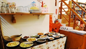 A buffet setup with various dishes and a floral tablecloth. - Birds Flower B&B (Wujie)