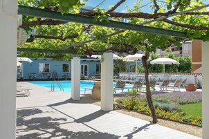 Una piscina al aire libre de temporada, sombrillas