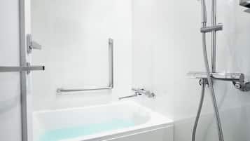 Un baño con bañera, ducha con cabezal de ducha extraíble y barra de apoyo.