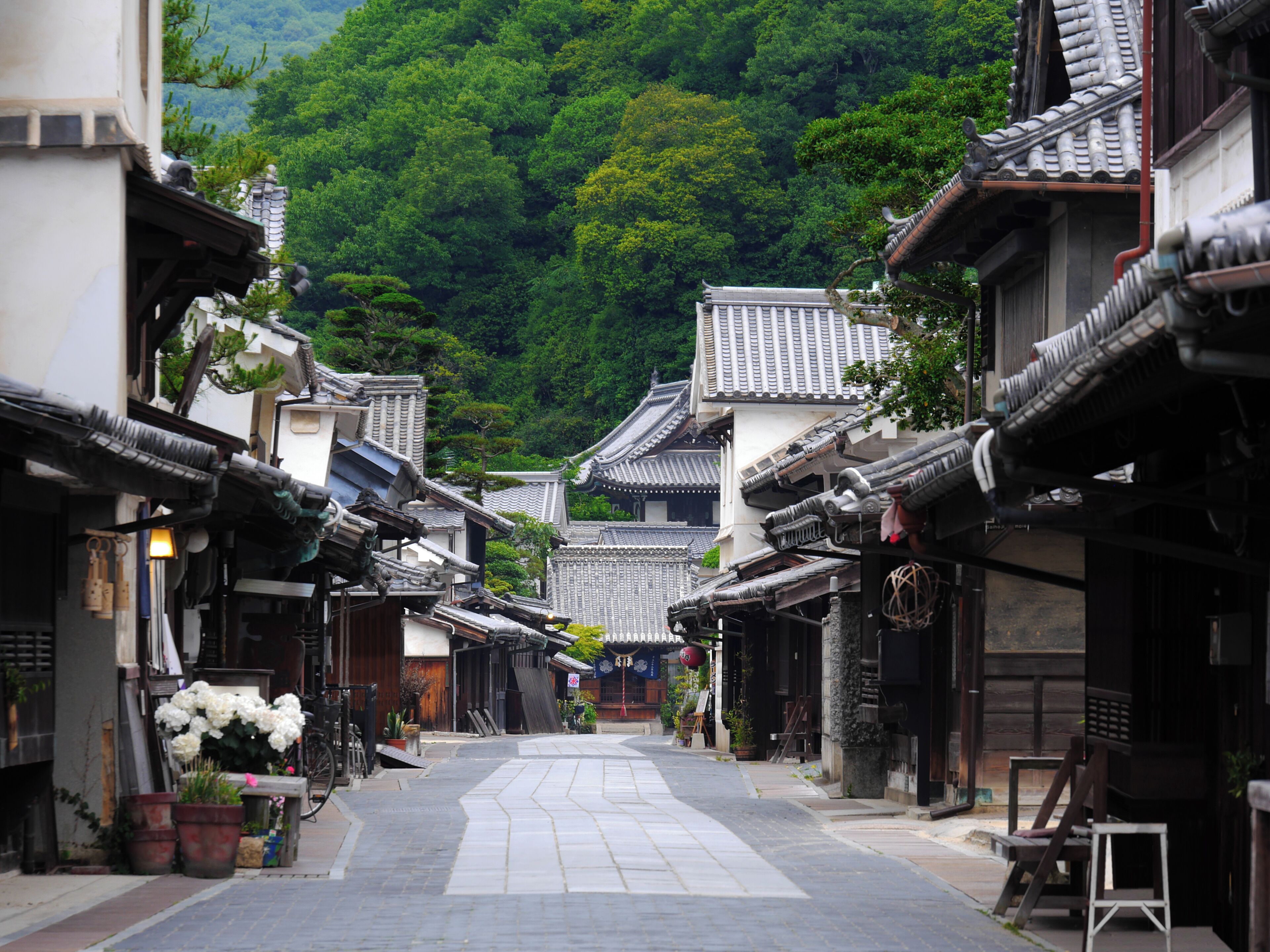 A traditional street with buildings featuring tiled roofs and wooden structures.