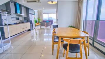 Una cocina moderna con comedor, ventanas amplias y vista al mar.