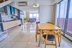 Een moderne keuken met een eethoek, grote ramen en uitzicht op zee.