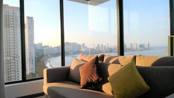 A modern living room with a large window offering a city view.