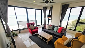 A modern living room with a sofa, armchairs, and a coffee table. - Family Suite Sunrise Gurney Penang (George Town)