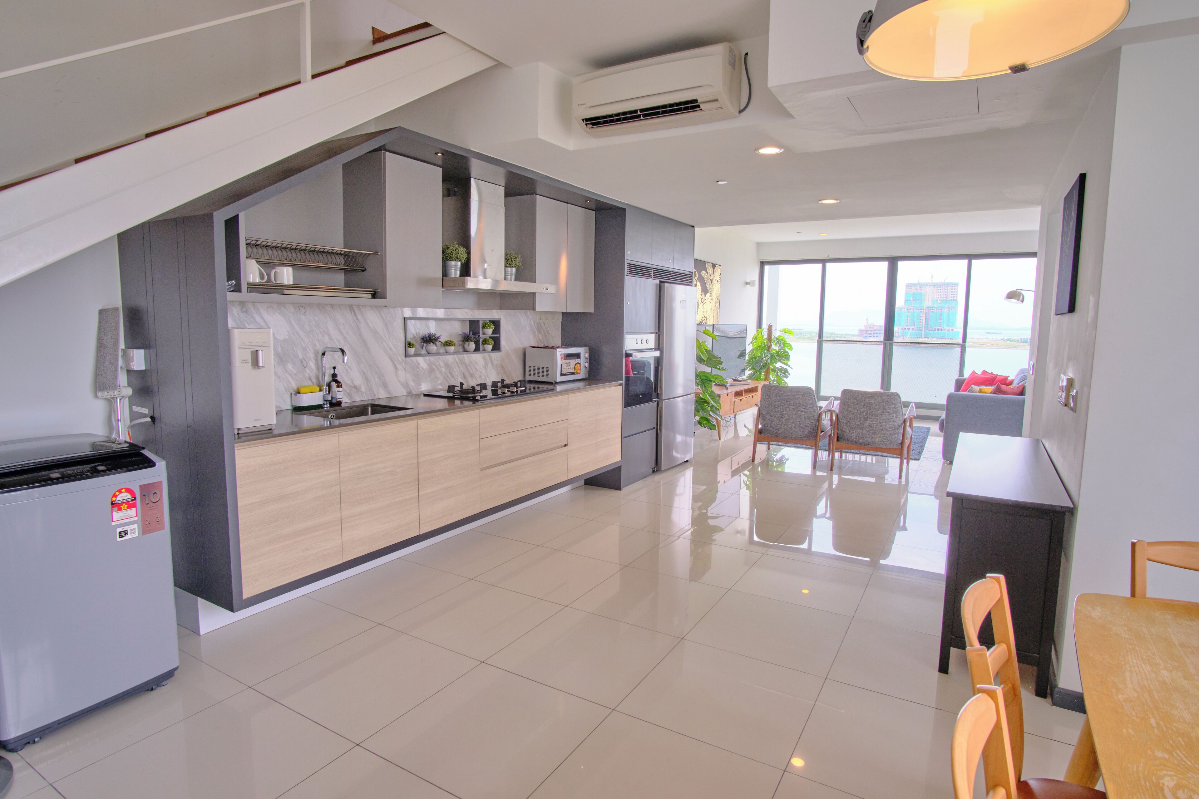 A modern kitchen with a built-in stove, microwave, and sink. There is a dining area with a table and chairs.