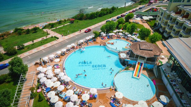 A large pool area with multiple swimming pools, sun loungers, and umbrellas. - Hotel Perla Beach Luxury (Primorsko)