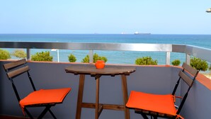 A balcony with two wooden chairs and a small table, overlooking the sea. - Panoramic Blue (Limassol)