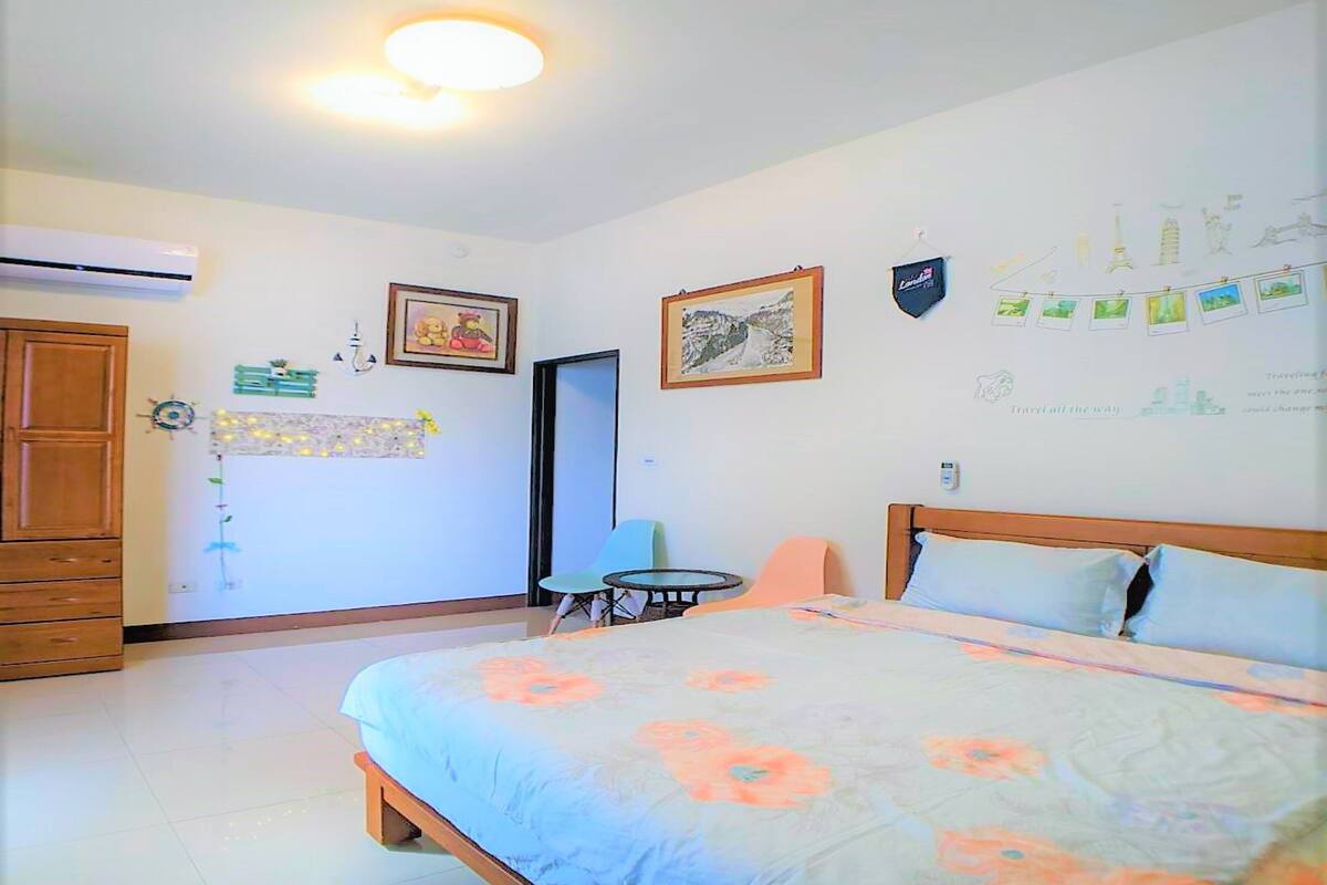 A bedroom with a bed, a wardrobe, a desk, and a chair.
