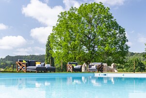 Una piscina al aire libre de temporada, sillones reclinables de piscina