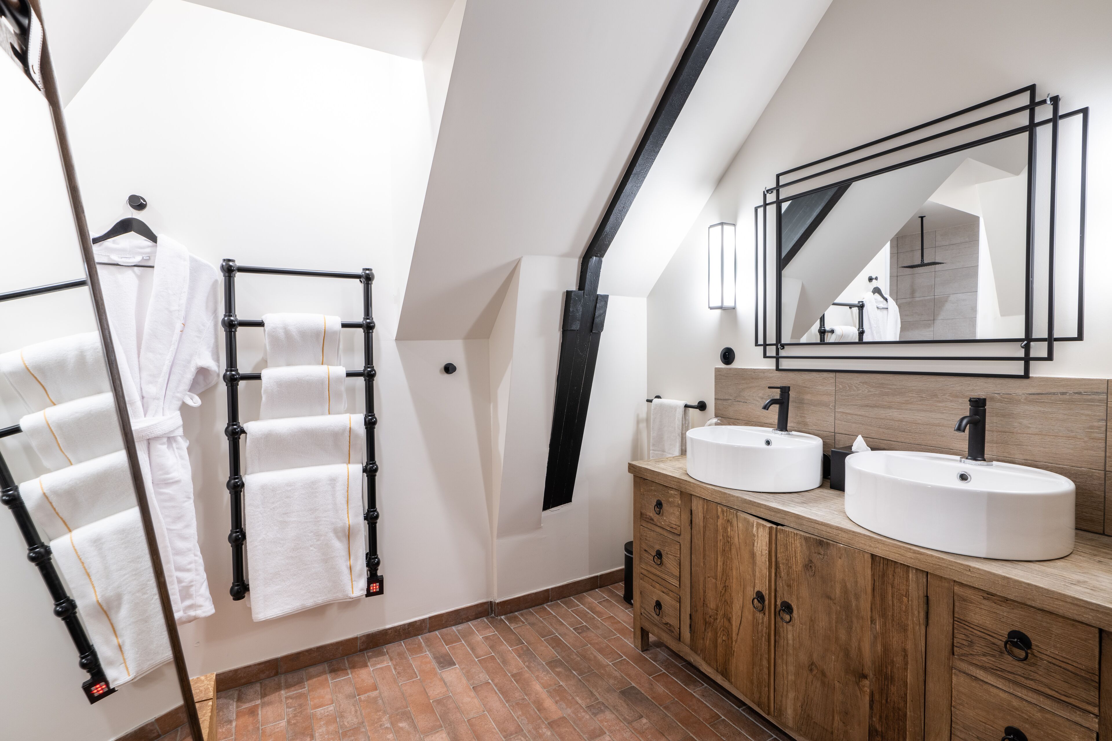 Une salle de bain moderne avec deux lavabos, un porte-serviettes et un grand miroir.