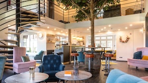 A modern lounge area with a spiral staircase, seating arrangements, and a bar area.
