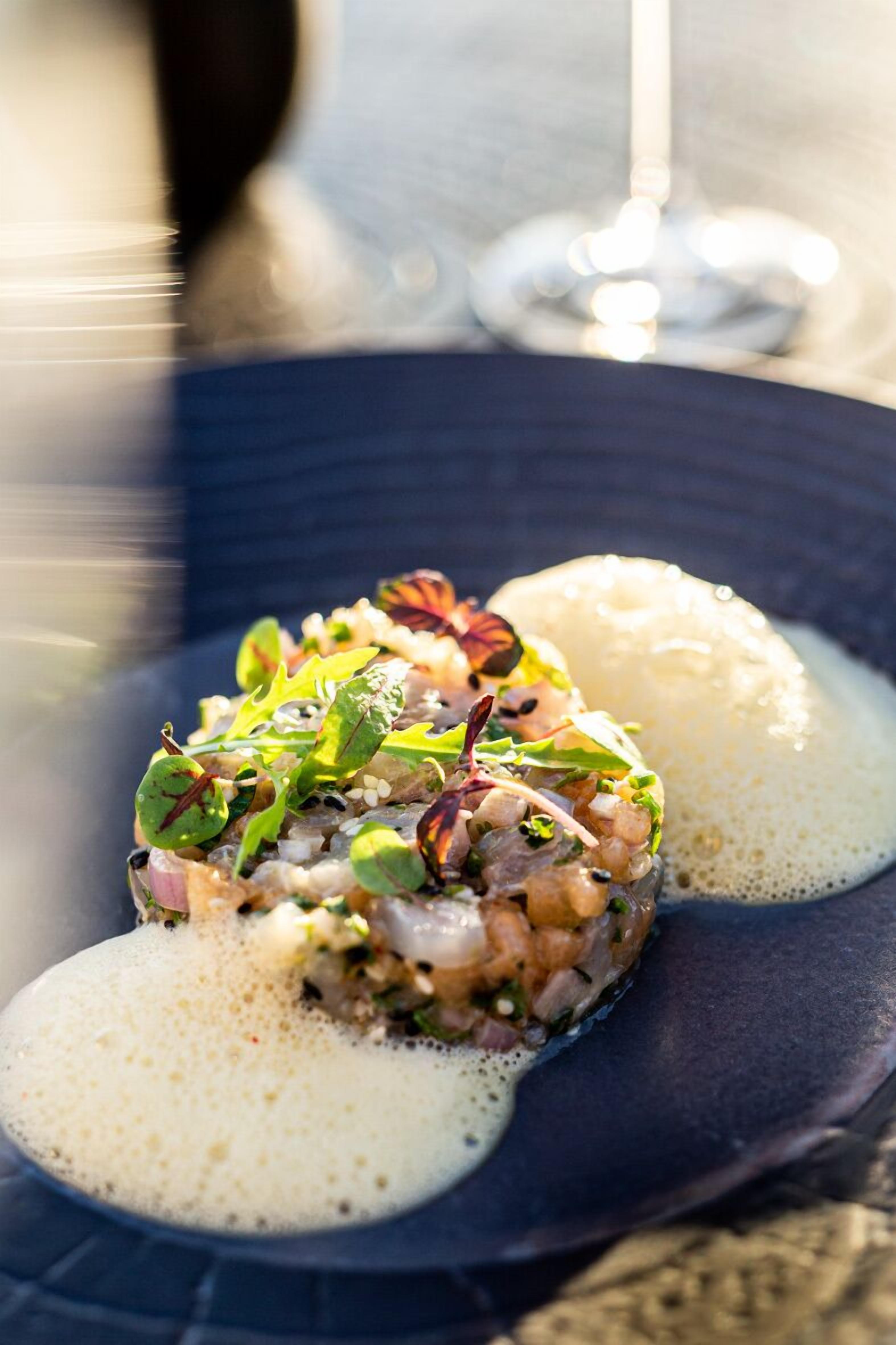 A dish with a creamy sauce and a dark plate.