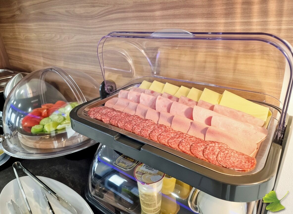 A buffet with various meats and cheeses.
