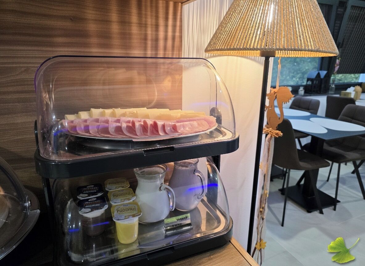 A breakfast station with a glass display case containing sliced bread, butter, and condiments.