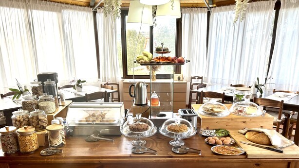 A breakfast buffet with various food items and utensils on a wooden table. - B&B Eyexei Domus (Agrigento)