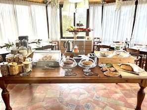 A breakfast buffet with various food items and utensils on a wooden table. - B&B Eyexei Domus (Agrigento)