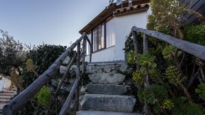 A stone staircase leading to a white building with a wooden handrail and a window. - B&B Eyexei Domus (Agrigento)