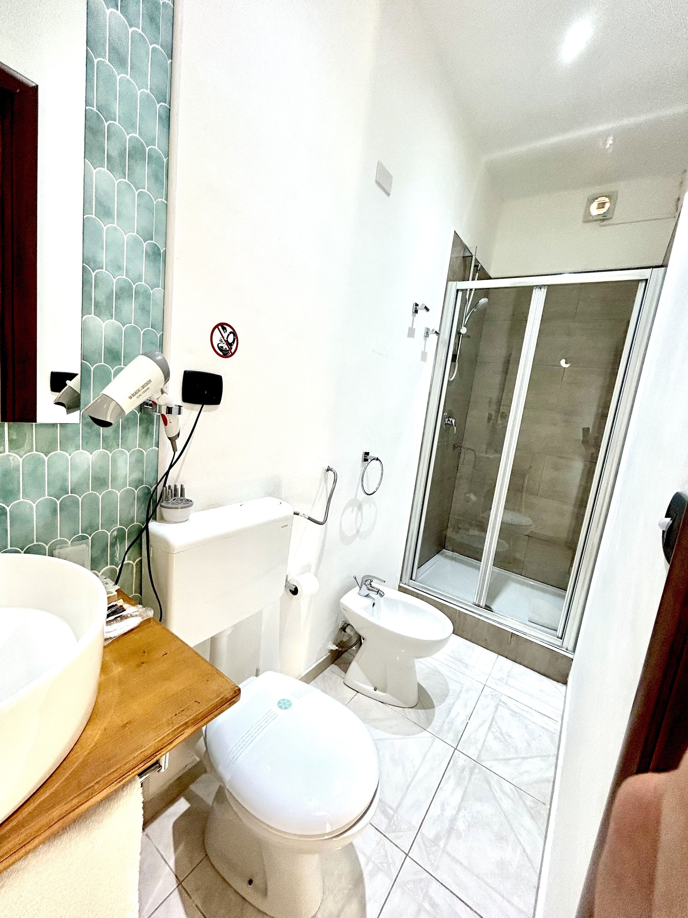 Un baño moderno con inodoro, bidé, lavabo y ducha.