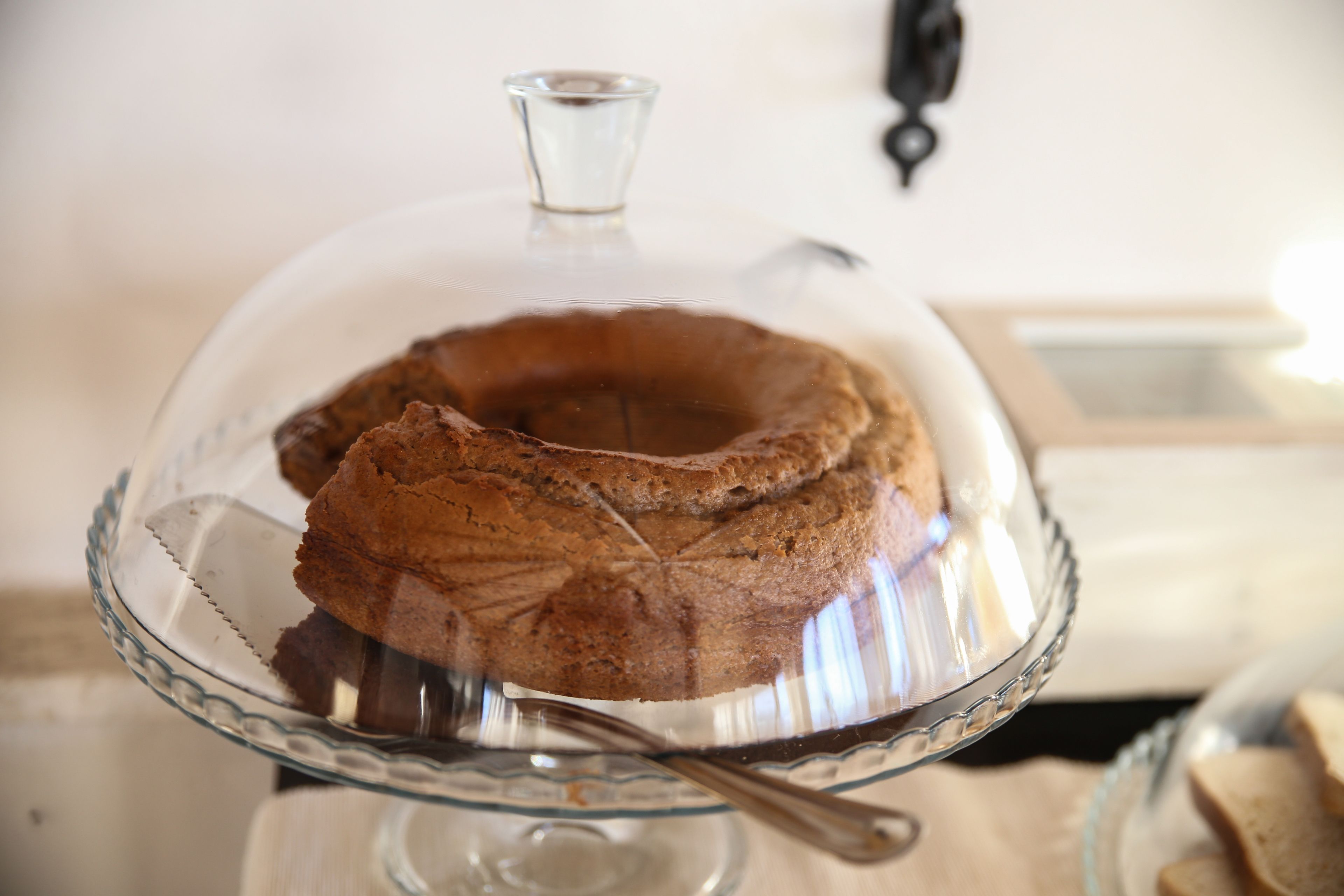 A cake on a glass cake stand with a clear glass dome.