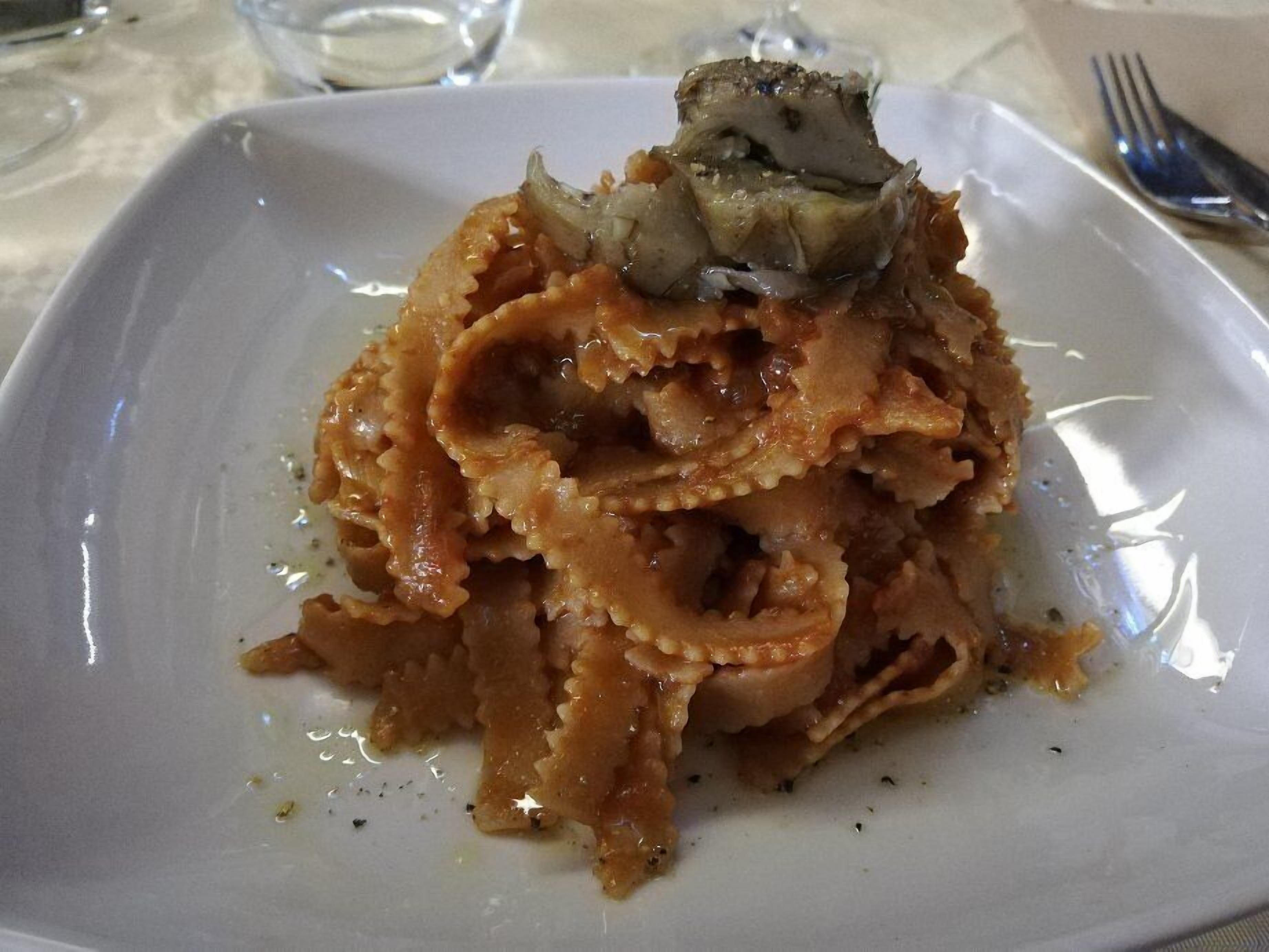 A plate of pasta with mushrooms on a white plate.