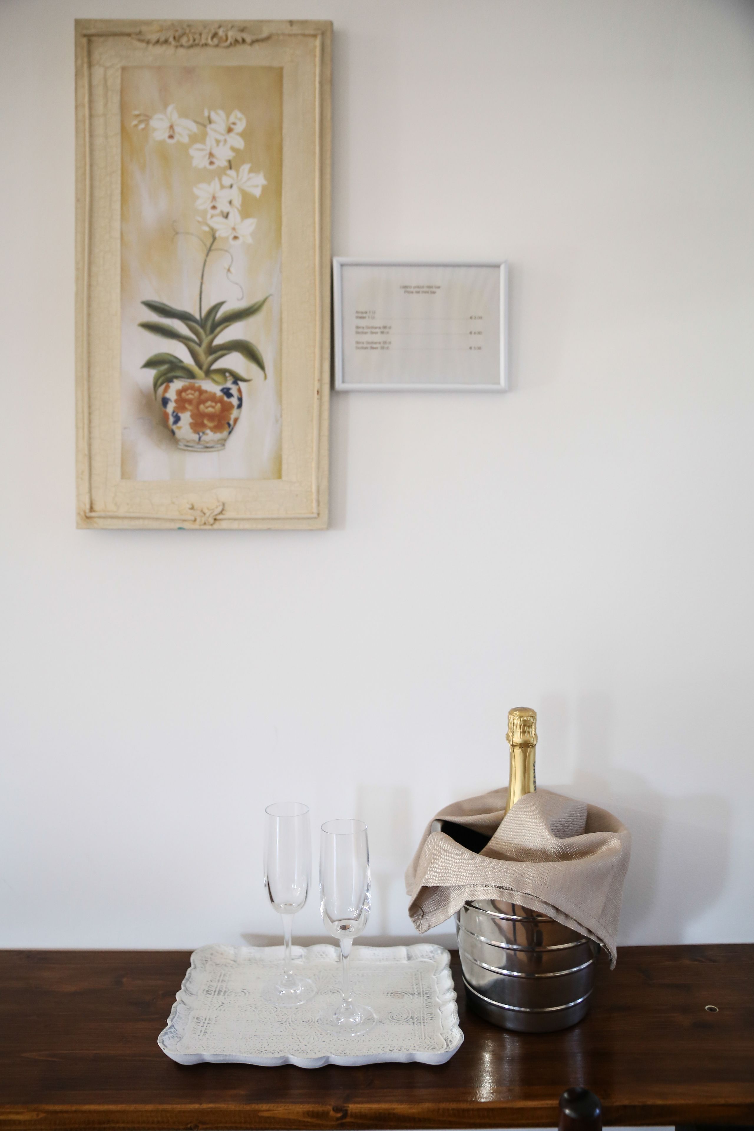 Une table avec un plateau décoratif, deux verres, une bouteille de champagne et un seau en métal.