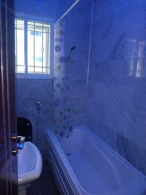 Bathroom features a bathtub and sink with a window above.