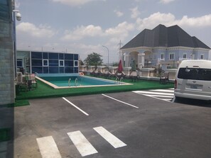 Relax by the rooftop pool surrounded by lush greenery and lounge under the shade of umbrellas.