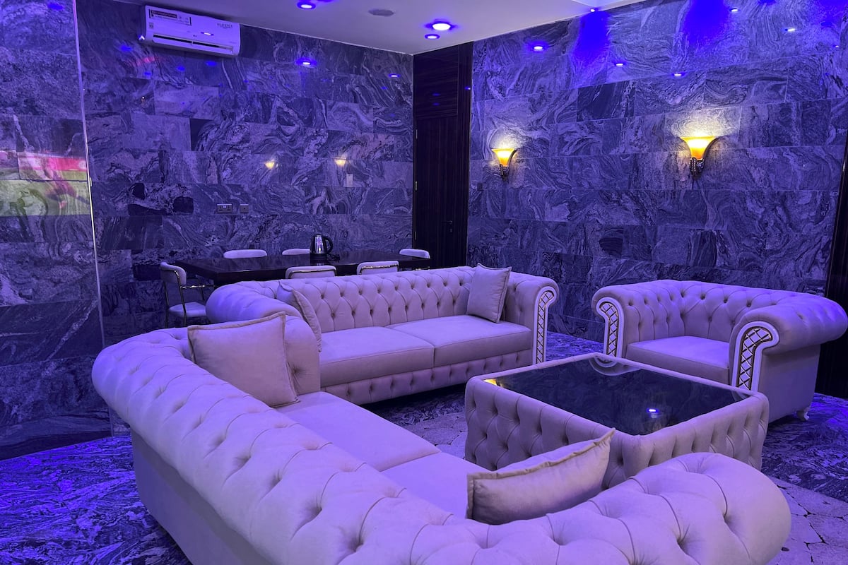 A luxurious room with a sectional sofa, armchairs, and a coffee table.