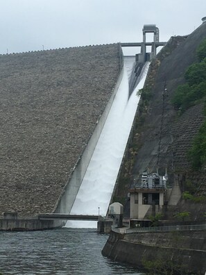 Ein großer Staudamm mit Wasserablass und Kontrollgebäude.