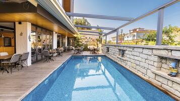 Una piscina al aire libre, sillones reclinables de piscina