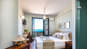 A hotel room with a bed, bedside tables, a lamp, a TV, and a balcony with a view. - Ink Hotels House of Europe (Rethymno)