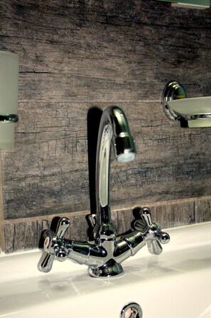 A bathroom with a modern faucet and a wooden textured wall. - Happy Home 3 (Limassol)