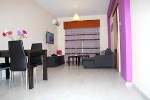 Apartemen, pemandangan laut terbatas | Area keluarga | TV layar datar