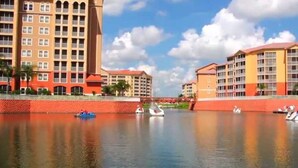 Ein Hotel am Wasserufer mit mehreren Gebäuden, einem ruhigen Fluss und einigen Booten.