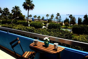 A balcony with a wooden table, two cups, and a flower vase. - Blue Home (Limassol)