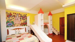 A bedroom with a bed, a colorful mural, a white staircase, and a door. - Staring East B & B (Hualien City)
