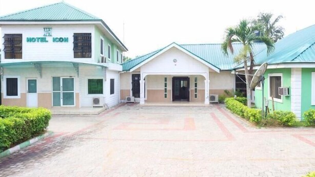 A hotel with a central entrance, a covered waiting area, and a green-roofed building labeled "HOTEL ICON". - Hotel Icon Limited (Calabar)