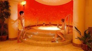 A spa area with a hot tub, steps leading to it, and potted plants.