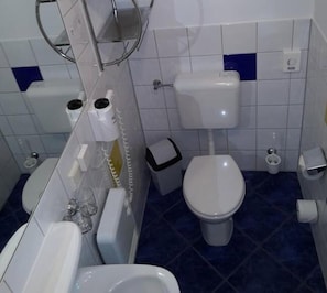 A bathroom with a toilet, bidet, and a sink. - Ferienpark Retgendorf (Dobin am See)