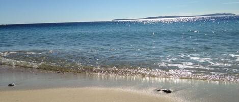 A beach with clear water and a sandy shore.