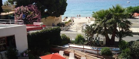 Una terraza con mobiliario exterior y vista a la playa.