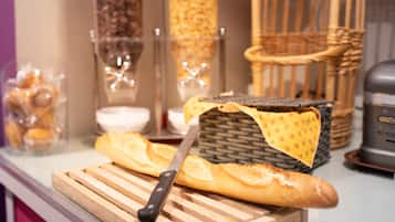 Ein Holzschnittbrett mit Brot und einem Messer auf einer Küchenarbeitsfläche.