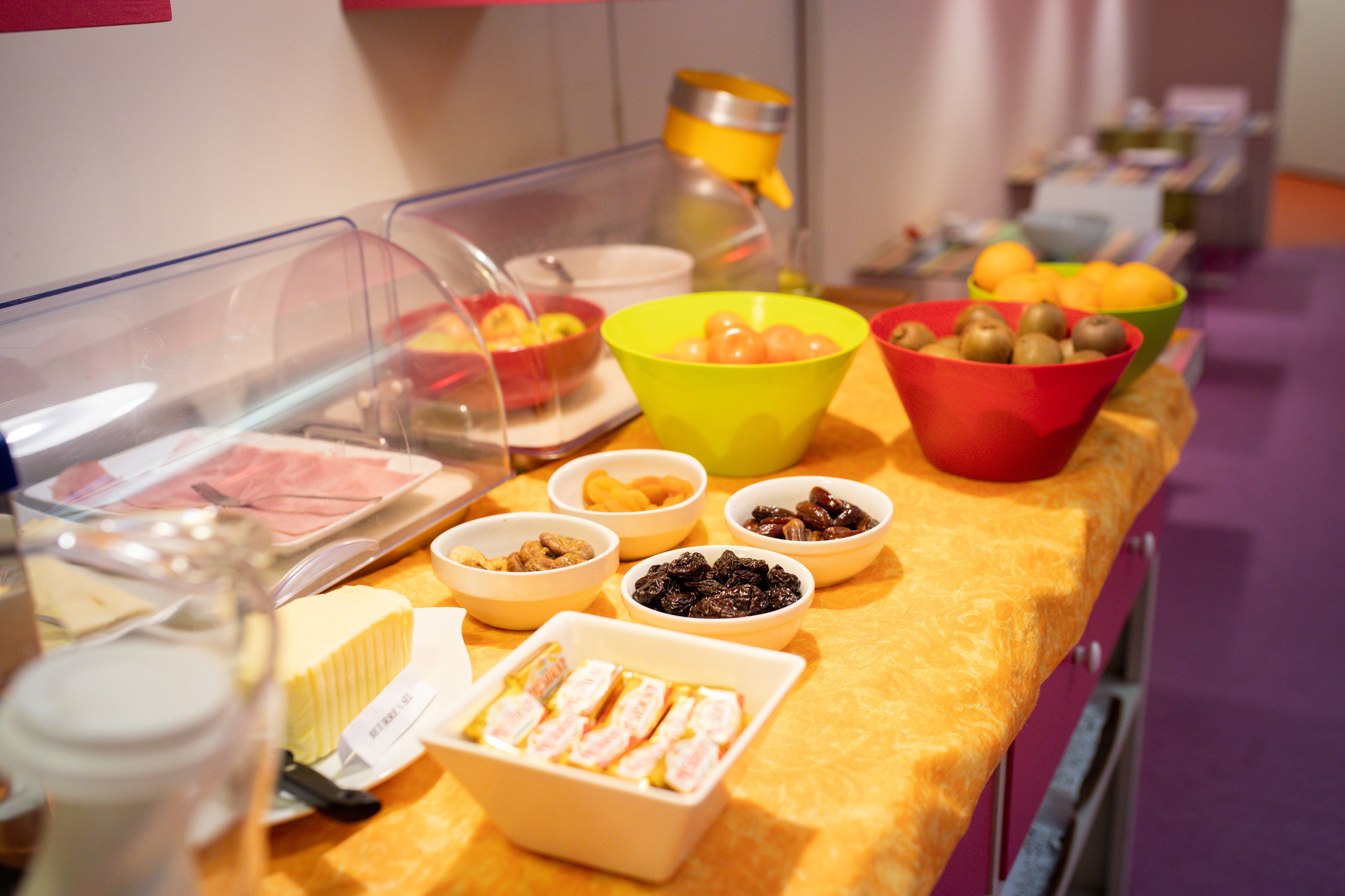 A buffet with various food items including fruits, nuts, and pastries.